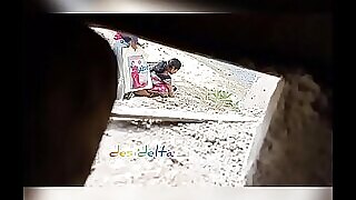 Érett indiai nő pisil egy mezőn egy softcore videóban.